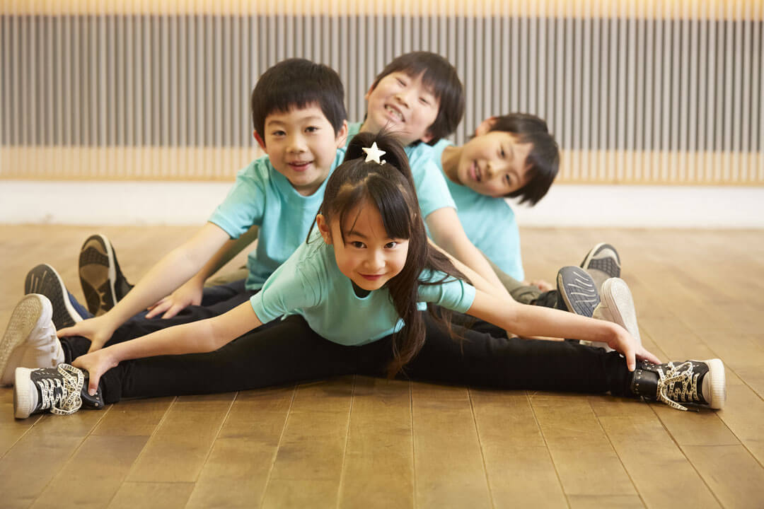柔軟体操をする4人の子供