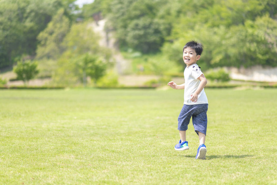 原っぱを走る男の子