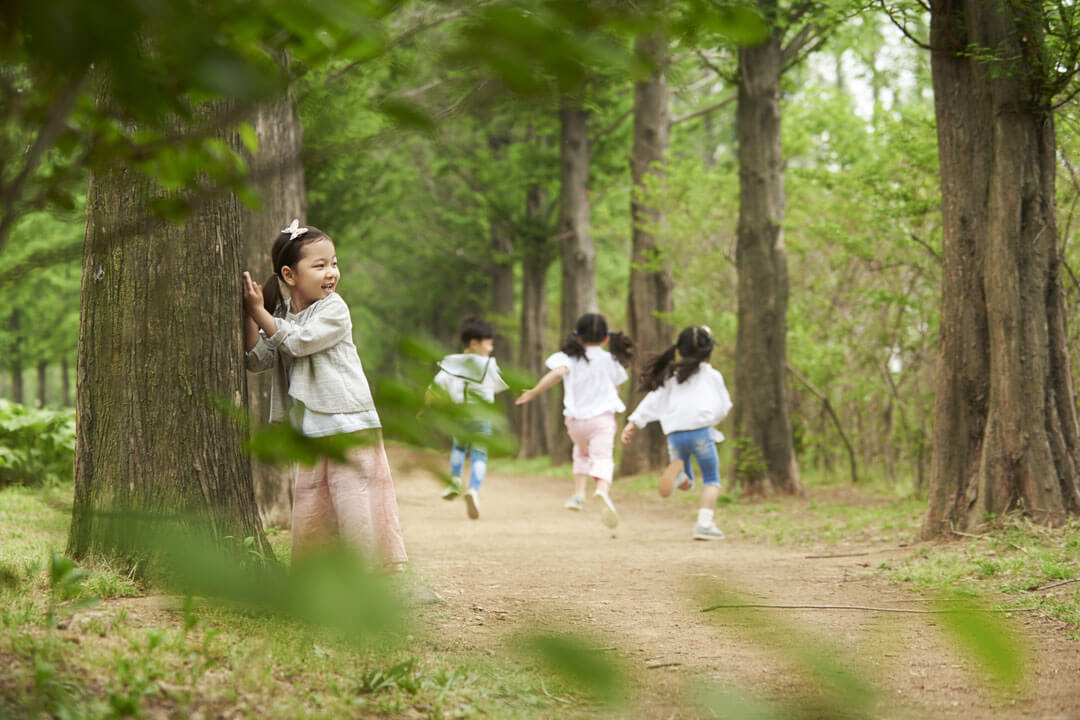 森の中でかくれんぼをする子供たち